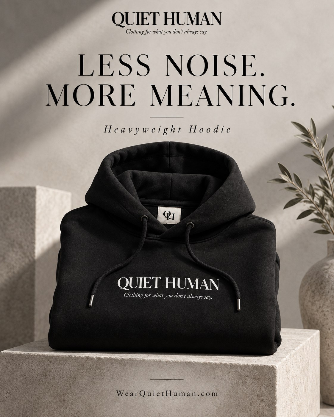 Black Quiet Human heavyweight hoodie concept on a stone pedestal
